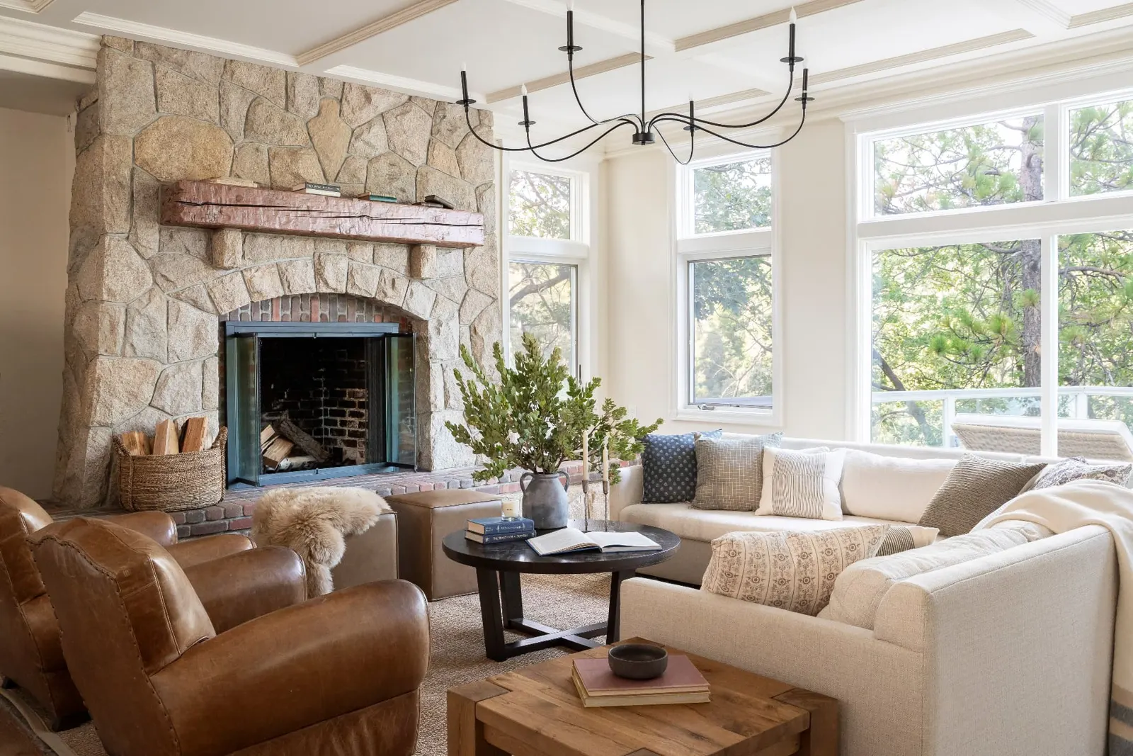 Living room with a stone fireplace and lake-facing windows